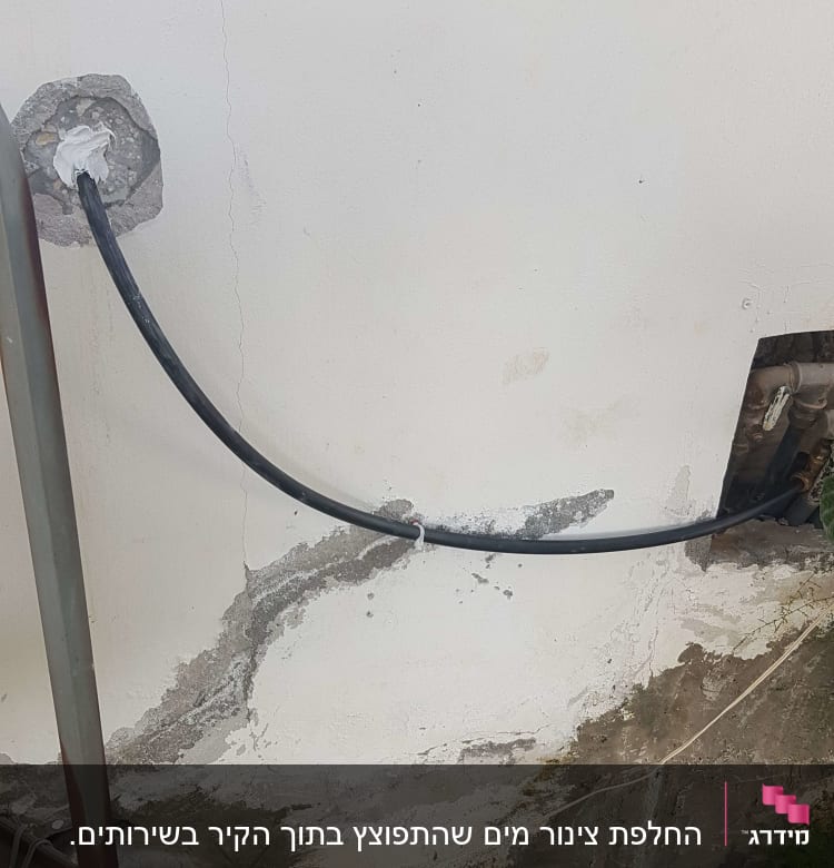צינור שחור מחובר לקיר עם חיבורי מתכת